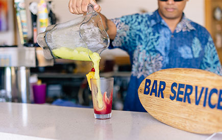 A bartender serves a drink at the bar